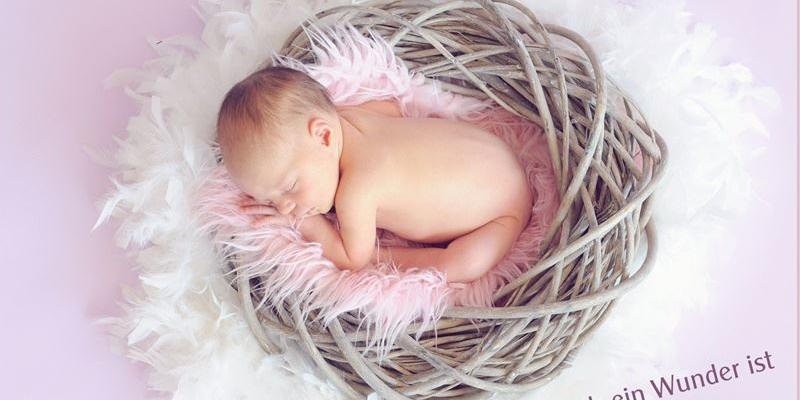 Baby im Weidenkorb rosa Hintergrund